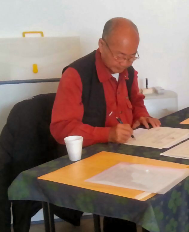 Immagine raffigurante il caposcuola Ming Wong C.Y. che firma gli attestati